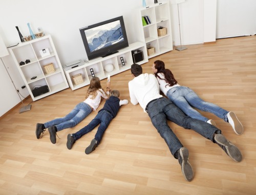 Young family watching TV together at home