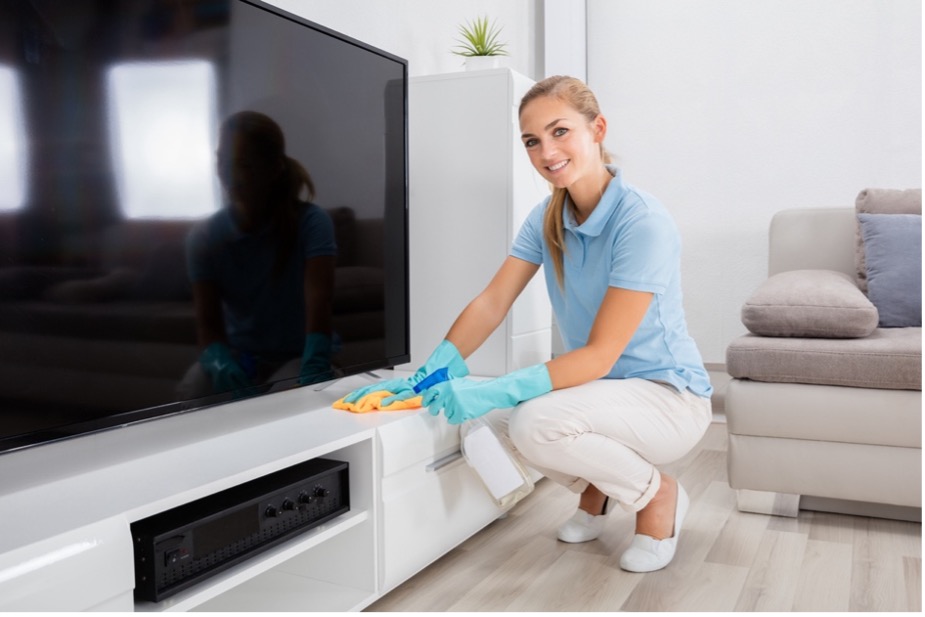 A person cleaning a tv