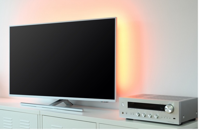 A tv and a stereo on a white cabinet